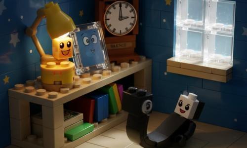 Pequeña lámpara antropomórfica de ladrillos amarillos y dorados, rostro sonriente pintado y ojos redondos brillantes, emite una cálida luz naranja; alegre y curiosa, está sobre una estantería LEGO. Una pequeña sombra estilizada de ladrillos negros y grises, con silueta flexible como una cinta y expresión de asombro, se desliza desde el borde hacia el suelo. Un reflejo espejo de LEGO plateado, secundario, con ojos pícaros dibujados, está junto a un marco plástico brillante mirando a la lámpara y a la sombra. Otro personaje, Silencio, representado por un gran reloj de ladrillos marrones y cobre con manecillas inmóviles, está al fondo en la misma estantería. Escenario: diorama de habitación LEGO con estantería color tostado, paredes azul noche con estrellas, cajas y libros, y una ventana cuadrada que deja pasar un rayo de luz. Situación: la sombra se aventura fuera de la estantería mientras la lámpara la observa con benevolencia, creando un marcado contraste entre la luz cálida y los tonos oscuros, atmósfera dulce y poética.