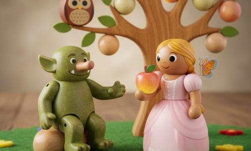 The princess (girl) is center, smiling with bright eyes, wearing a pale pink ruffled dress and braided blonde hair, delicately holding a colorful apple from the magic tree; a troll (boy, about 30 in appearance, tall and stocky) is left, green textured skin and a big smiling mouth, sitting on a wooden rock and reaching toward the princess; Bella the butterfly rests on the princess’s right shoulder with small iridescent orange-and-blue wings; Oliver the owl perches on a low branch, brown feathers and round eyes looking kindly at the princess; the setting is an enchanted clearing with felt green grass, glued colorful flowers, a large gnarled tree bearing glowing bead-like fruits, and soft golden light filtering through the leaves; the main scene shows the discovery of the treasure of friendship as the princess picks a glowing fruit while her friends surround her, warm joyful atmosphere, toy diorama composition with wood and felt textures, bright colors and crisp outlines.